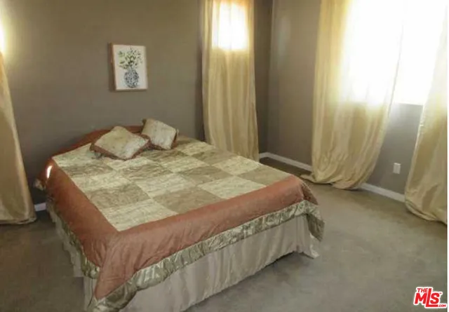 a bed sitting in a bedroom next to a window