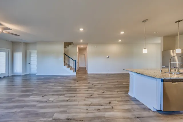 a view of a kitchen with a sink and wooden floor