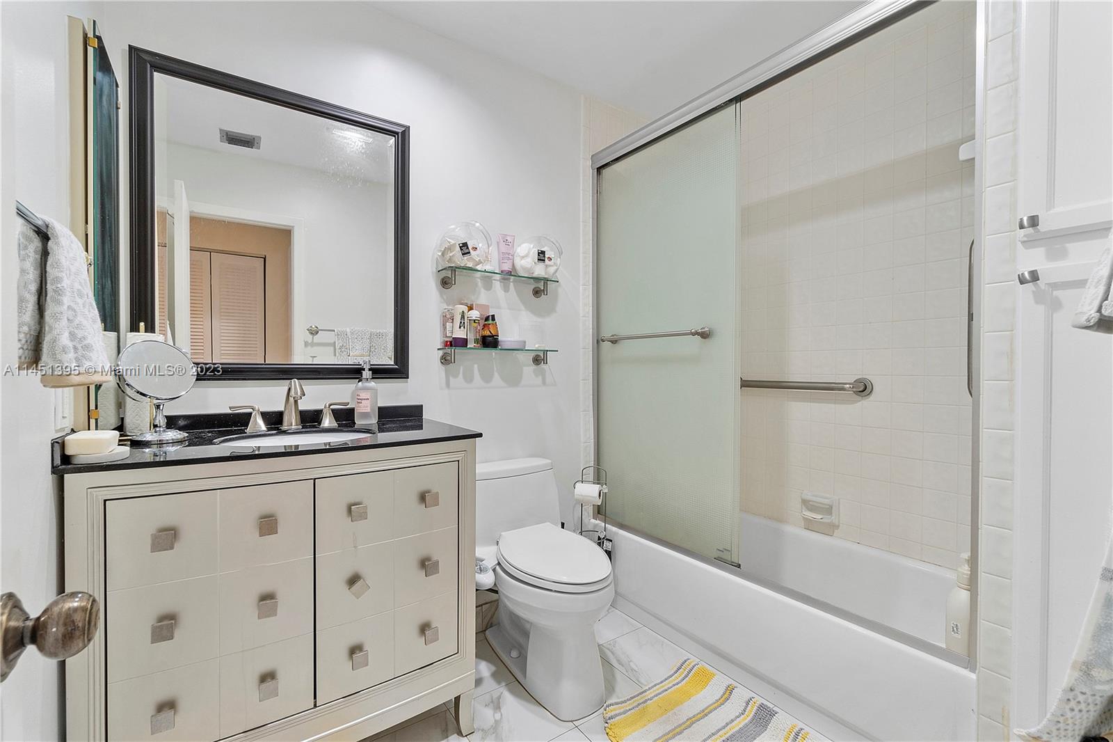 6157 Old Court Road, Unit 225 Boca Raton, FL 33433 - Photo 12 of 27 a bathroom with a granite countertop sink a toilet and a mirror
