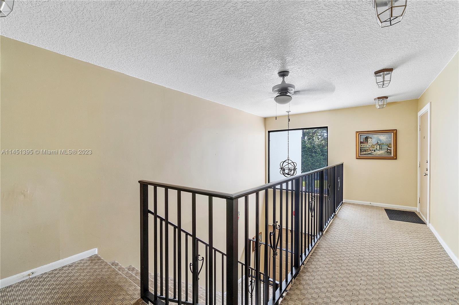 6157 Old Court Road, Unit 225 Boca Raton, FL 33433 - Photo 2 of 27 a view of a hallway with a window and a chandelier fan