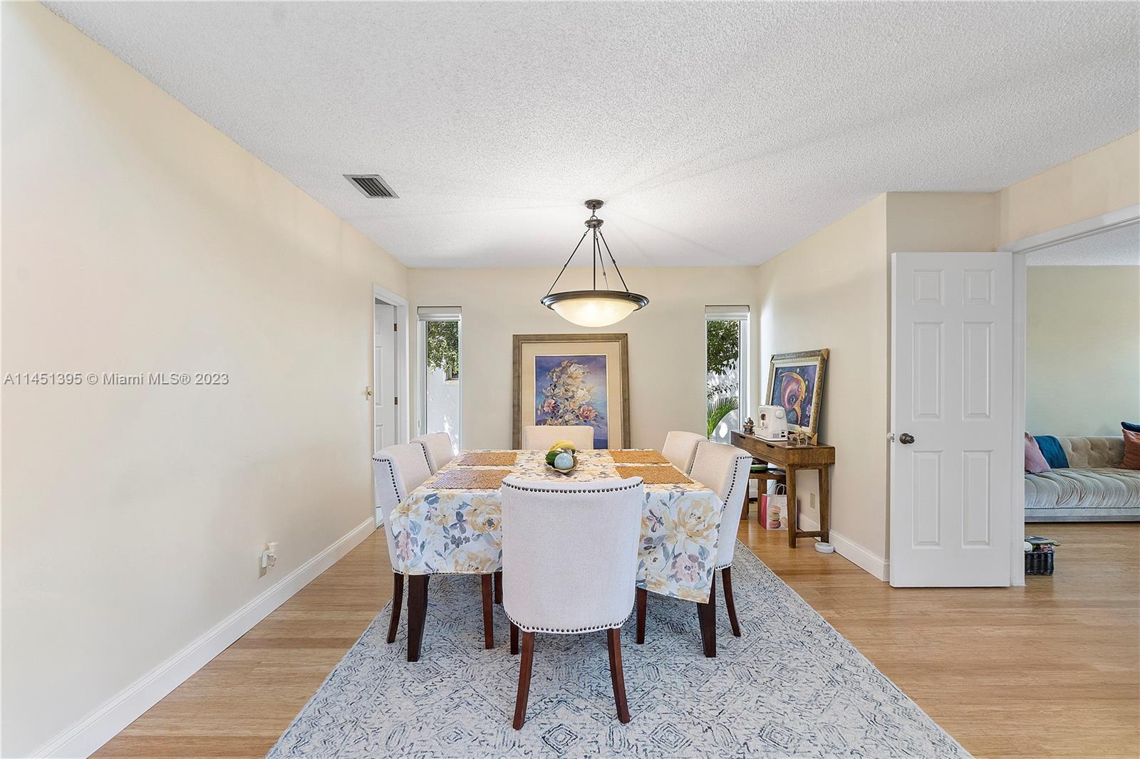 6157 Old Court Road, Unit 225 Boca Raton, FL 33433 - Photo 26 of 27 a dining room with furniture wooden floor a rug and a chandelier