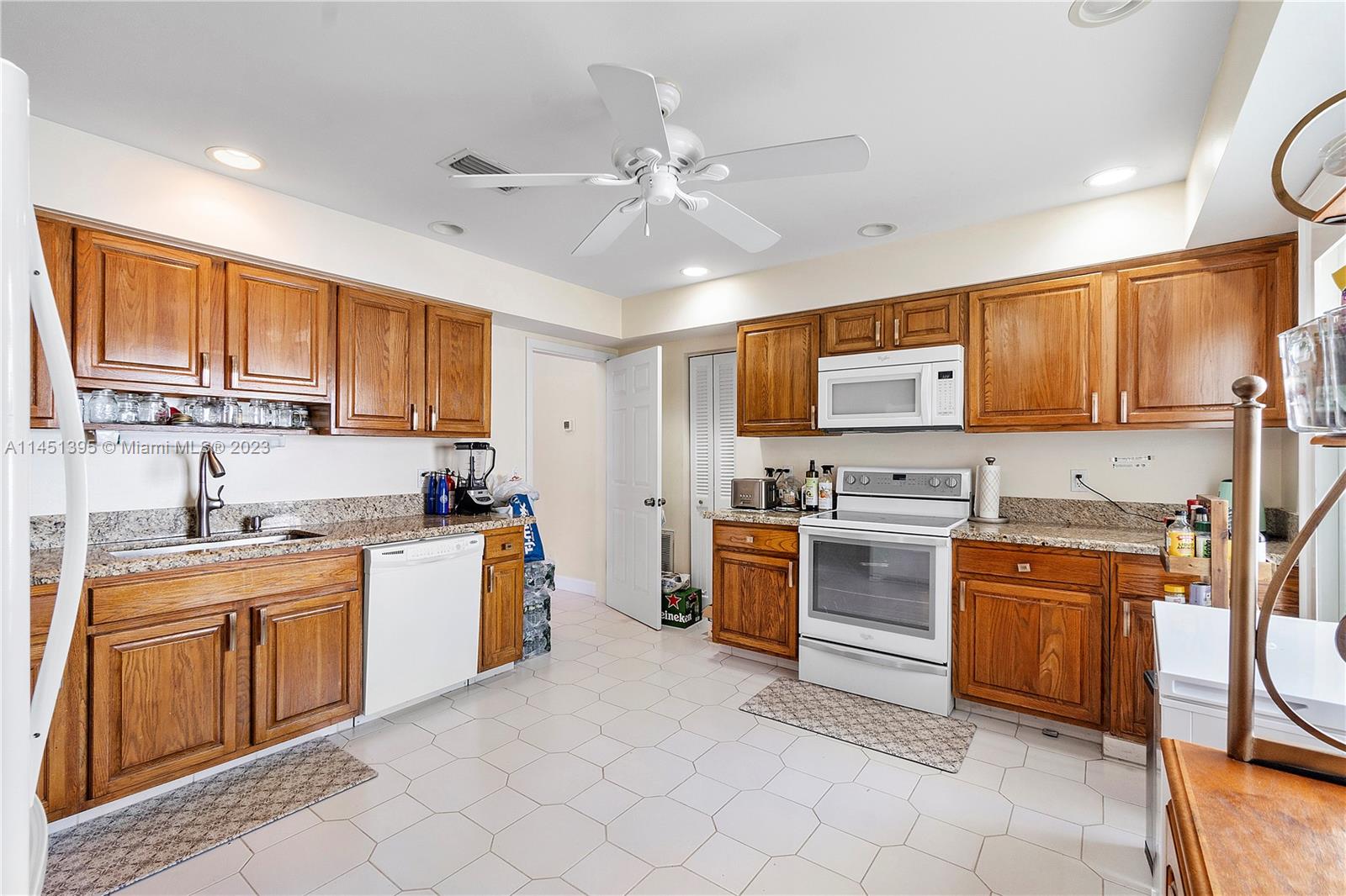 6157 Old Court Road, Unit 225 Boca Raton, FL 33433 - Photo 10 of 27 a kitchen with stainless steel appliances granite countertop a stove top oven a sink dishwasher a dining table and chairs with wooden cabinets