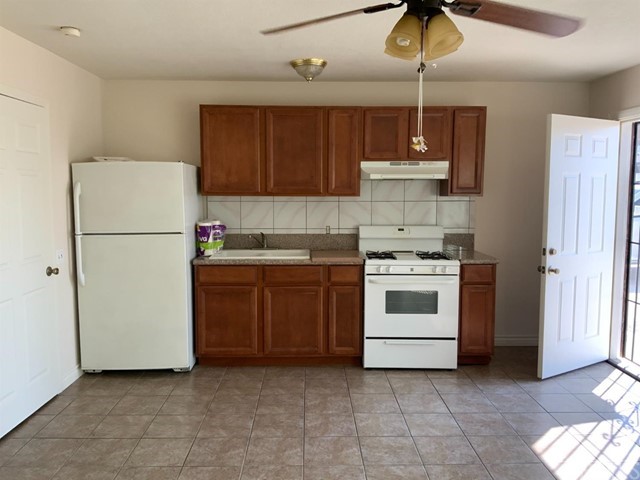 9450 Mango Avenue Hesperia, CA 92345 - Photo 10 of 14 a kitchen with a stove a refrigerator and cabinets