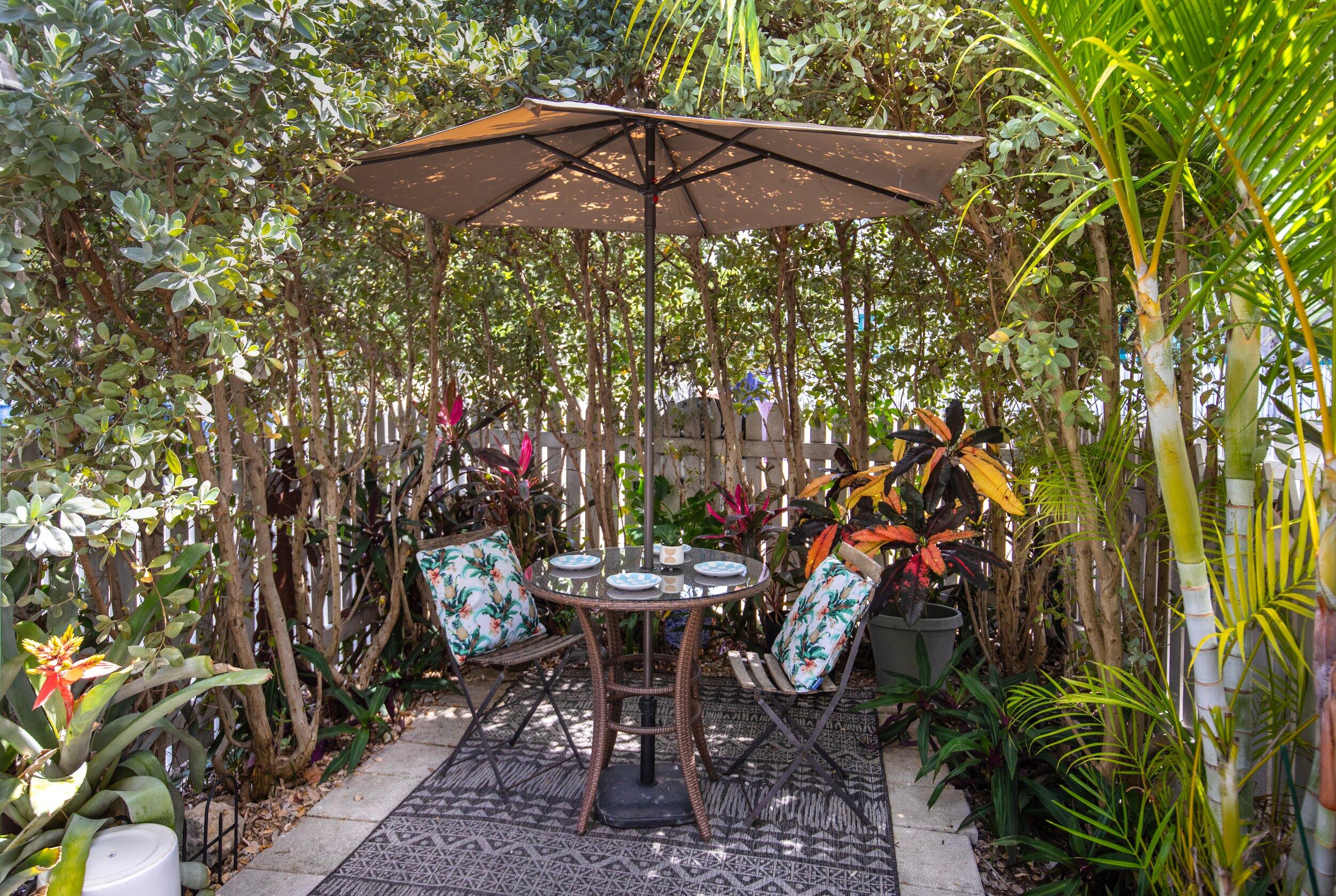 900 White Street, Unit 2 Key West, FL 33040 - Photo 23 of 24 a backyard of a house with table and chairs under an umbrella
