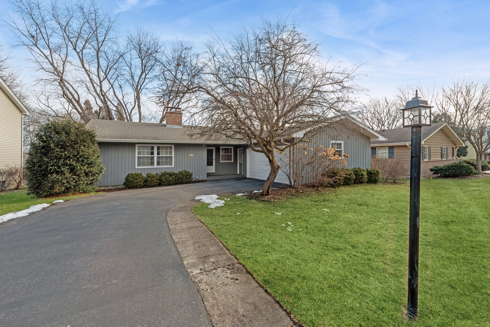 a front view of a house with a yard and trees