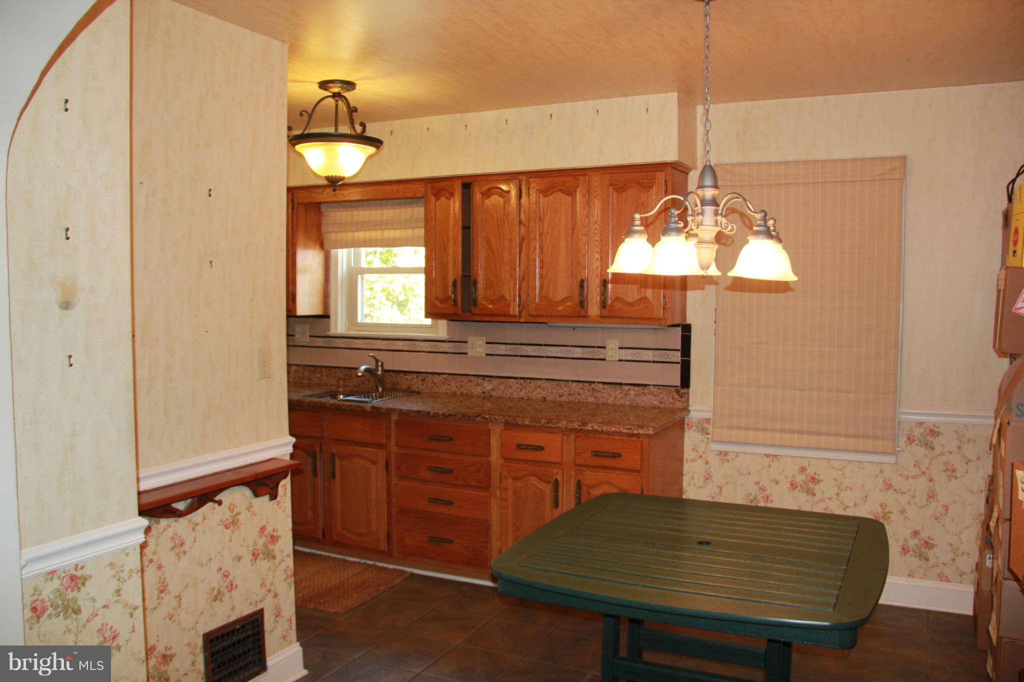 6502 Sharon Road Baltimore, MD 21239 - Photo 4 of 14 a kitchen with a table and chandelier