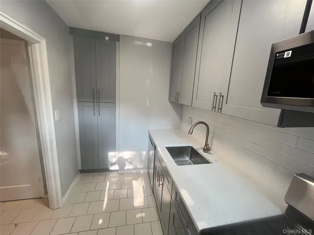 a kitchen with a sink a refrigerator and cabinets