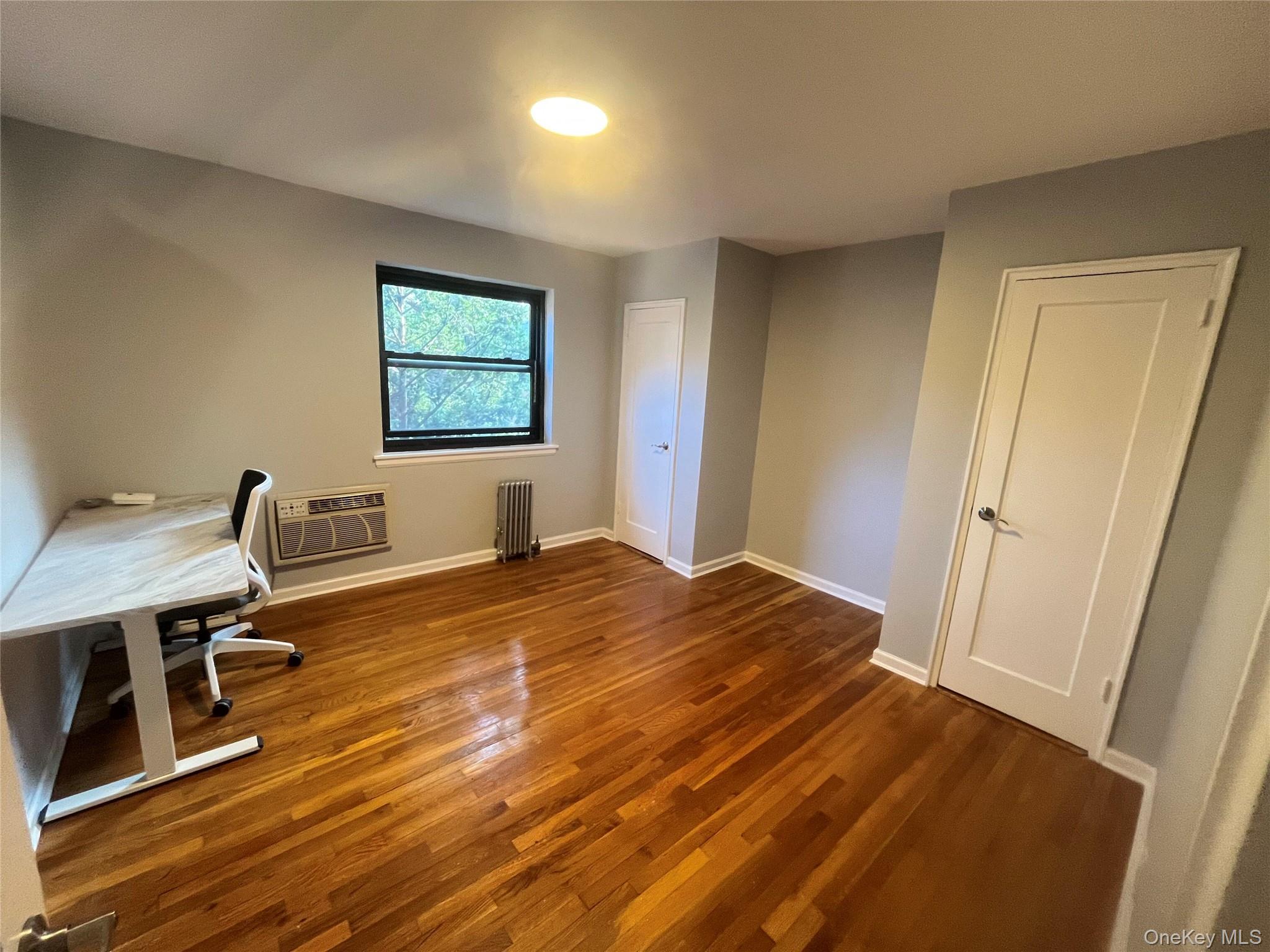 46-40 216th Street, Unit 3B Queens, NY 11361 - Photo 7 of 11 a bedroom with a bed and wooden floor