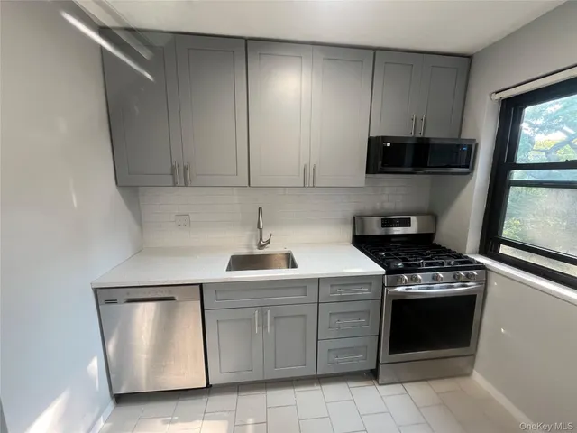 a kitchen with white cabinets and appliances