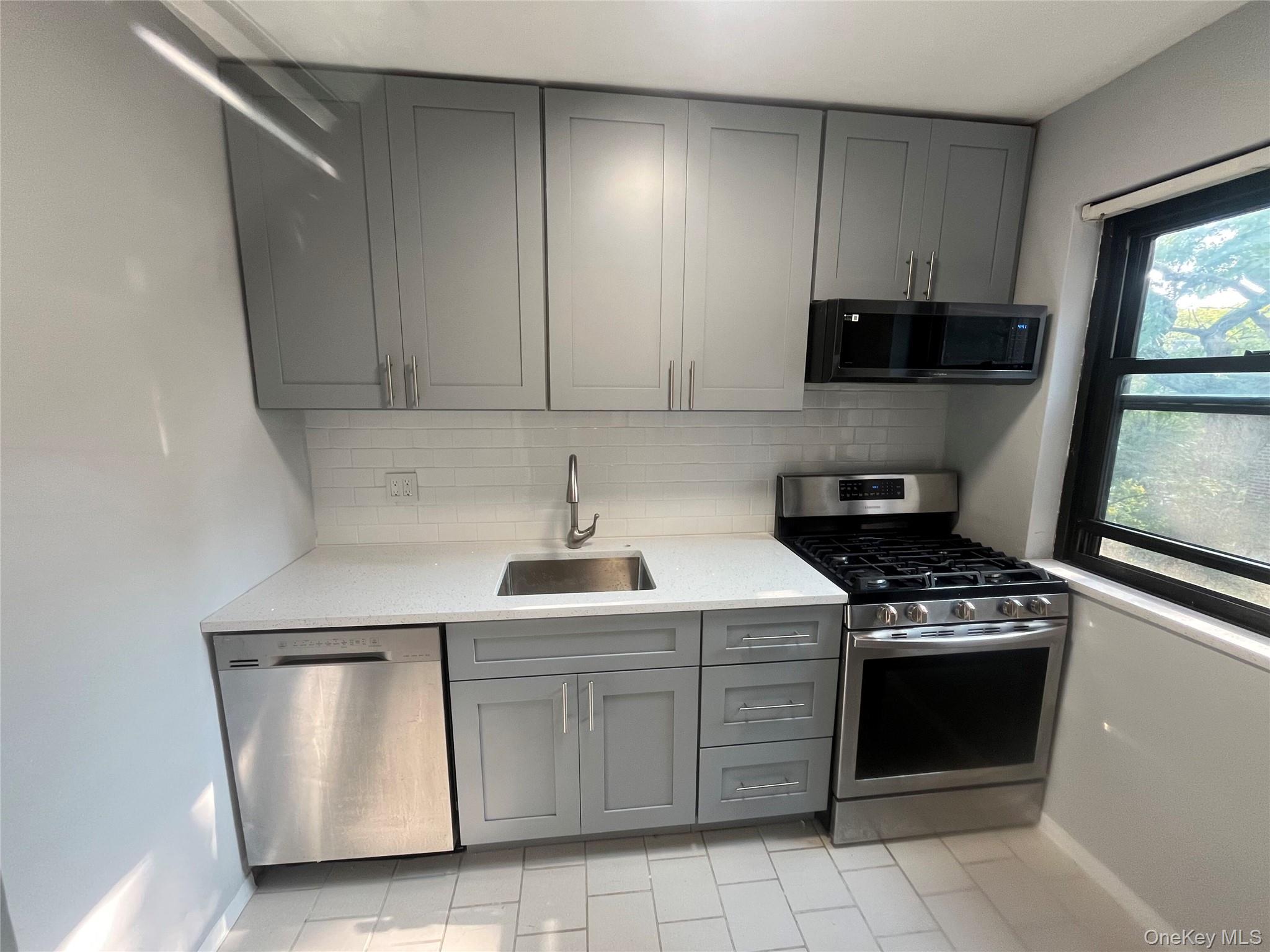 46-40 216th Street, Unit 3B Queens, NY 11361 - Photo 10 of 11 a kitchen with white cabinets and appliances