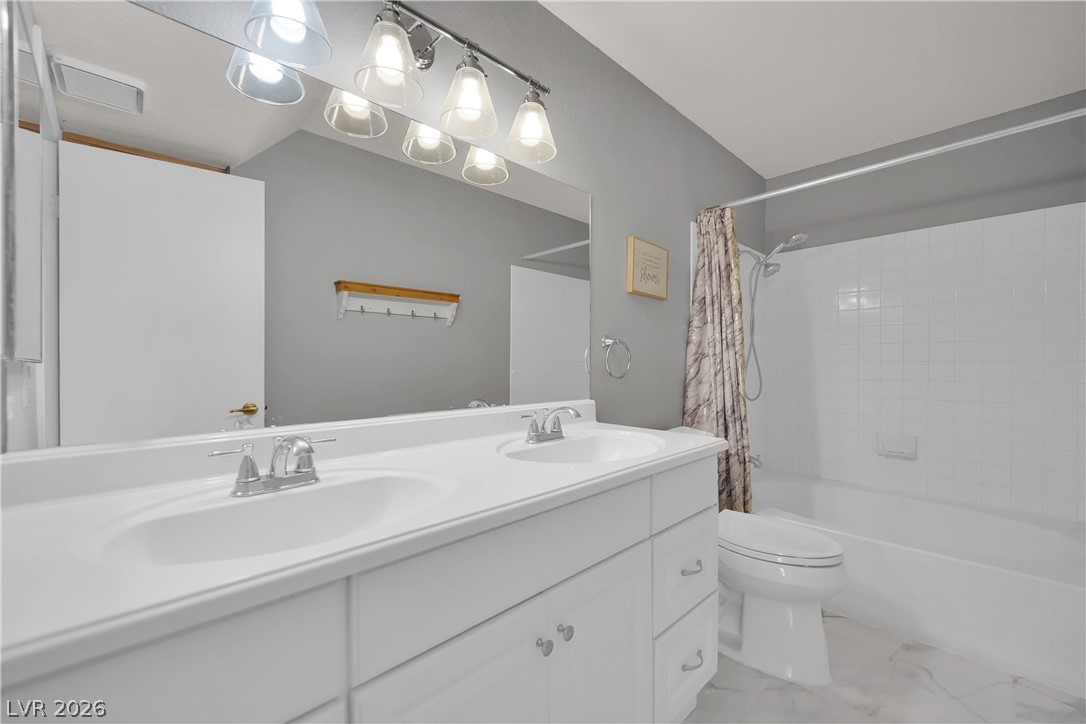 7570 West Flamingo Road, Unit 115 Las Vegas, NV 89147 - Photo 18 of 34 A well-appointed bathroom features a bright double vanity, providing ample space for daily routines.