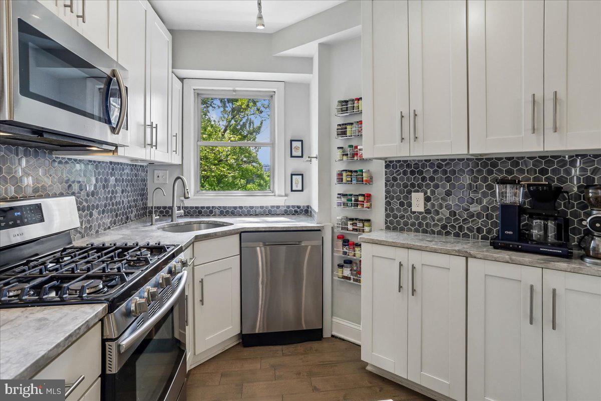 2500 Q Street Northwest, Unit 605 Washington, DC 20007 - Photo 11 of 48 a kitchen with stainless steel appliances a sink stove and microwave