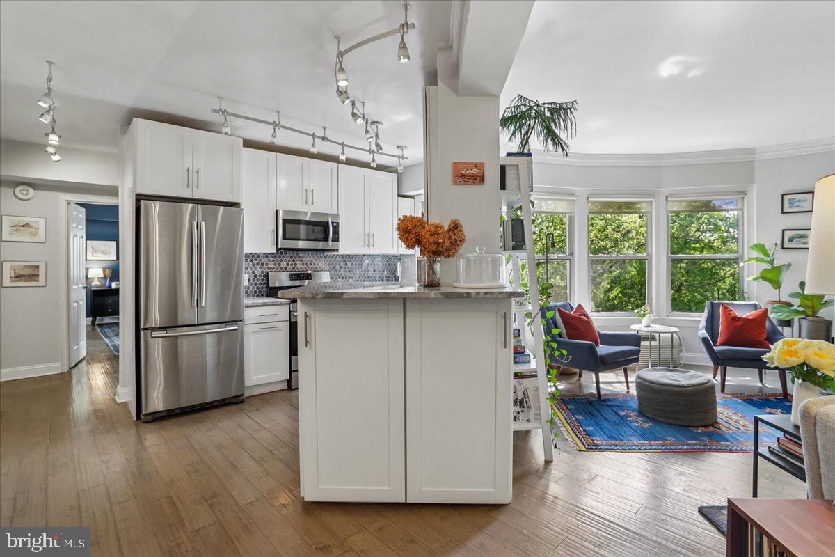 2500 Q Street Northwest, Unit 605 Washington, DC 20007 - Photo 12 of 48 a kitchen with a sink stainless steel appliances and wooden floor