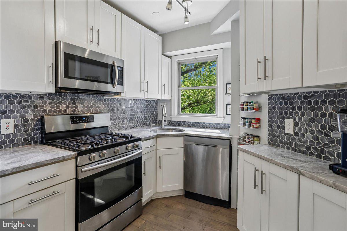 2500 Q Street Northwest, Unit 605 Washington, DC 20007 - Photo 13 of 48 a kitchen with white cabinets appliances and a sink