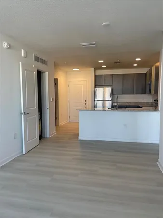 a view of a kitchen with a refrigerator and a sink
