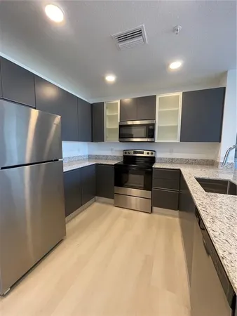 a kitchen with stainless steel appliances granite countertop a sink and a stove