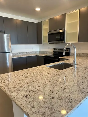 a kitchen with granite countertop a sink and a stove top oven