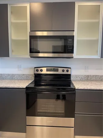 a kitchen with granite countertop a stove and a microwave
