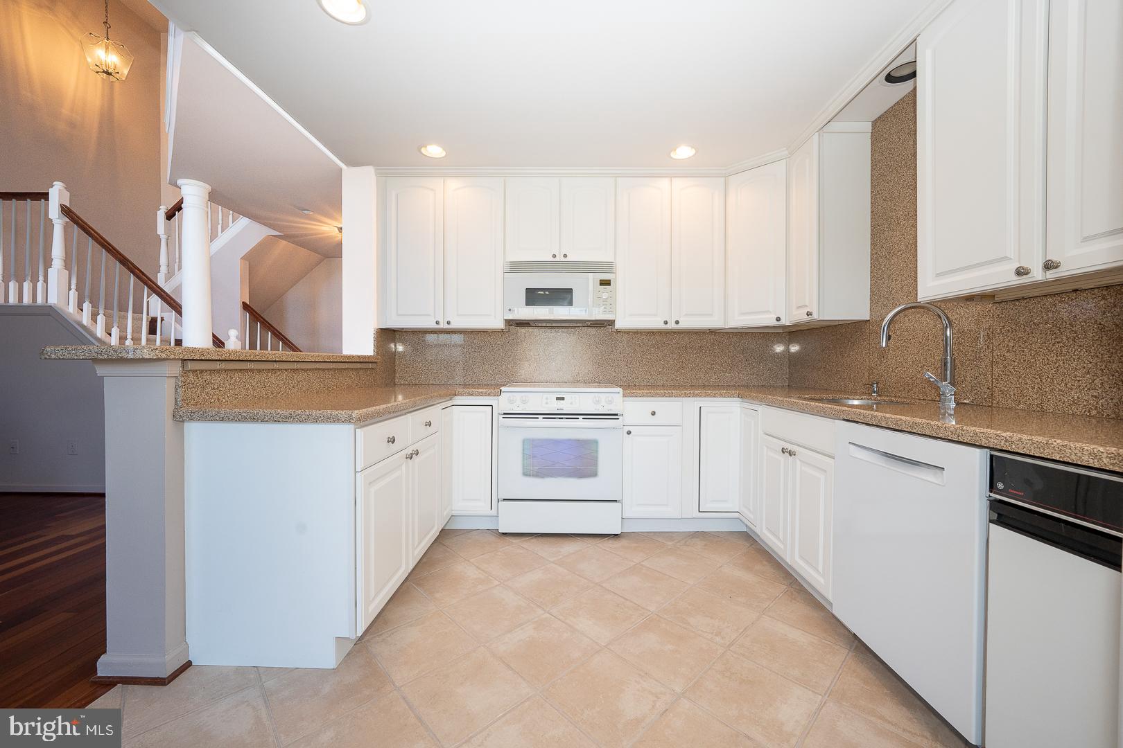 234 Lookout Place Wayne, PA 19087 - Photo 6 of 32 a kitchen with white cabinets and white appliances