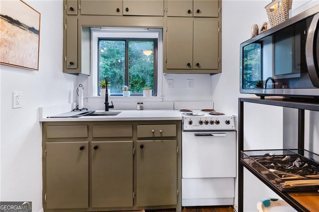 511 East Boyd Road Hogansville, GA 30230 - Photo 27 of 28 a kitchen with stainless steel appliances a sink stove and white cabinets with wooden floor
