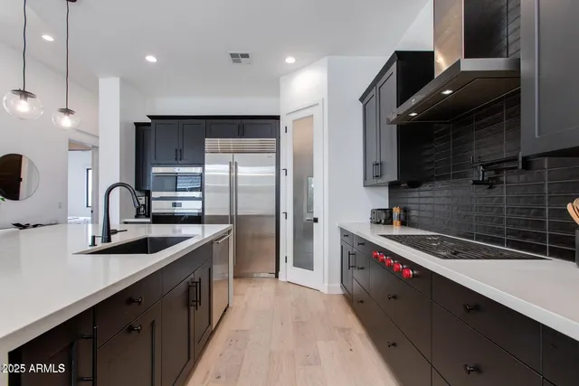 a kitchen with kitchen island granite countertop a sink stainless steel appliances and cabinets
