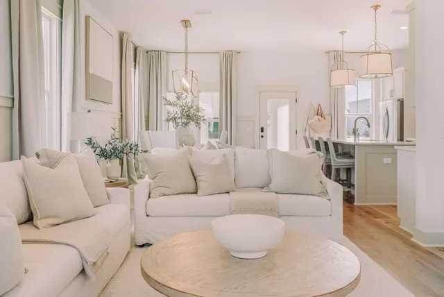 a view of a dining room and livingroom with furniture wooden floor kitchen chandelier