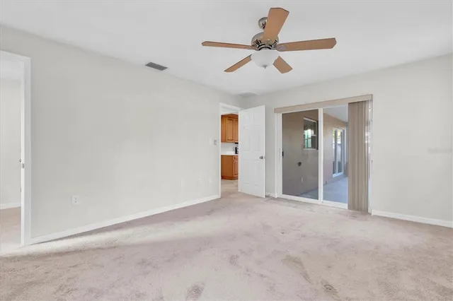 a view of a livingroom with a ceiling fan and entryway