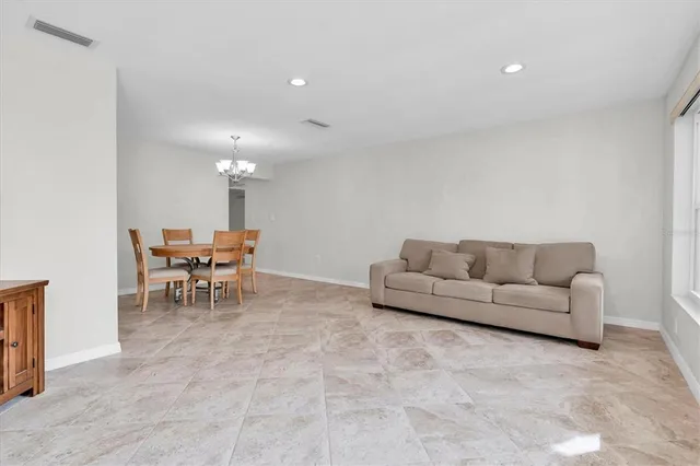 a living room with furniture and a dining table with a sink