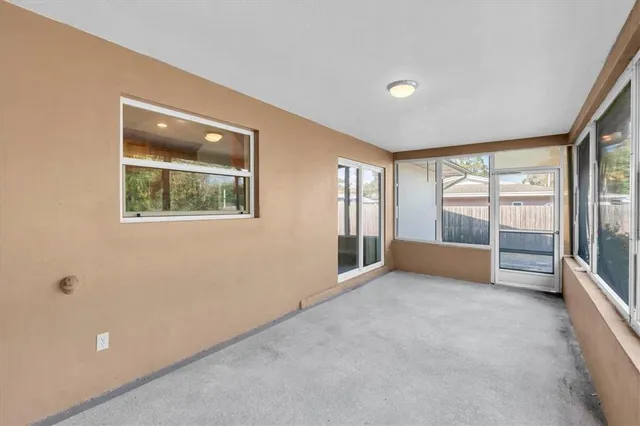 an empty room with windows and pool table