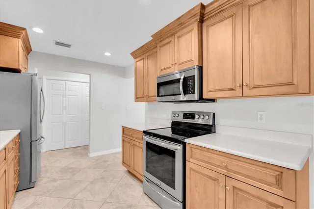 a kitchen with granite countertop a stove top oven microwave and cabinets