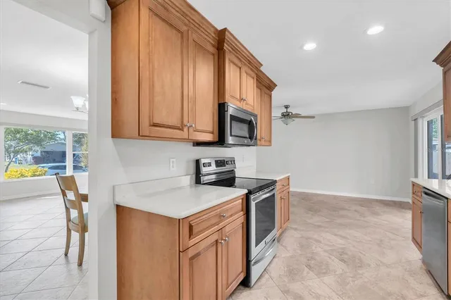 a kitchen with stainless steel appliances granite countertop a stove a sink and a microwave
