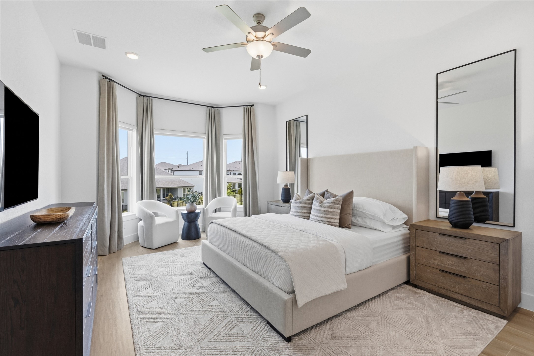836 Villa Rialto View Leander, TX 78641 - Photo 14 of 33 Ample natural illumination fills this restful primary bedroom, highlighting its expansive windows and tasteful flooring.