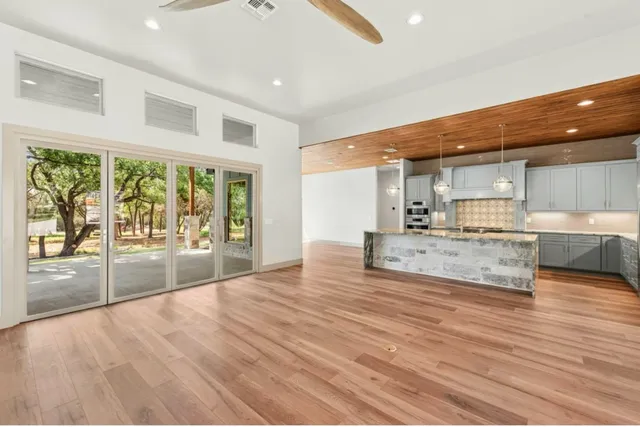 a view of large living room with wooden floor and a large window
