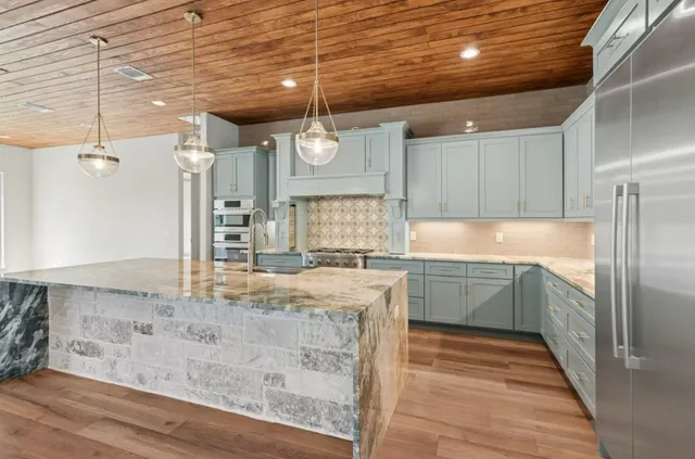 a kitchen with granite countertop a sink and cabinets