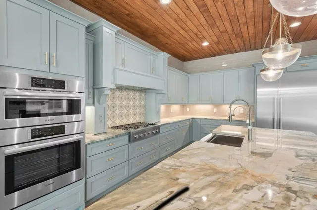 a kitchen with granite countertop a stove and cabinets