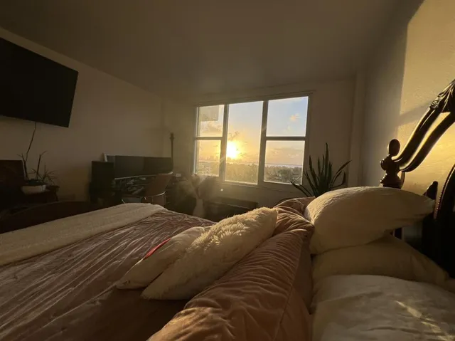 a bedroom with a bed and a flat tv screen on a dresser
