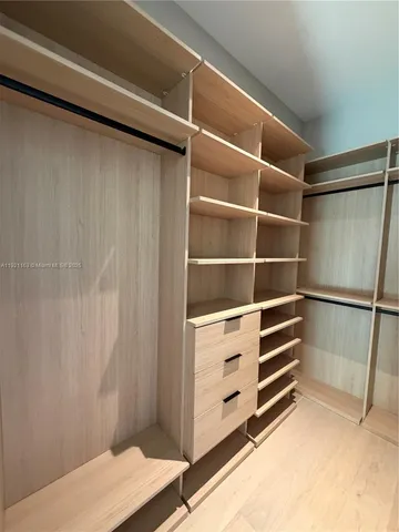 a view of walk in closet with empty racks