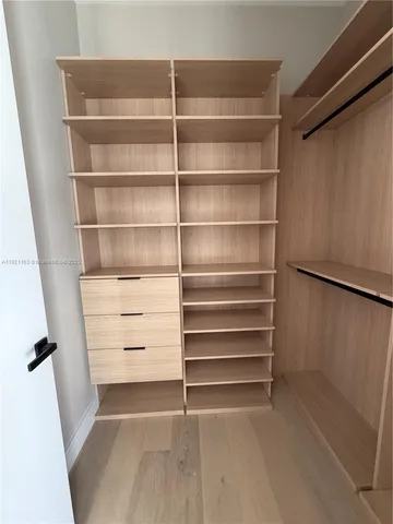 a room with walk in closet and empty racks