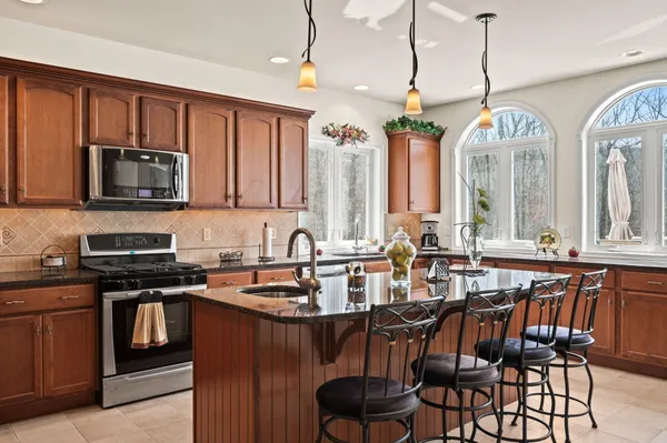a kitchen with kitchen island granite countertop a sink counter top space and living room view