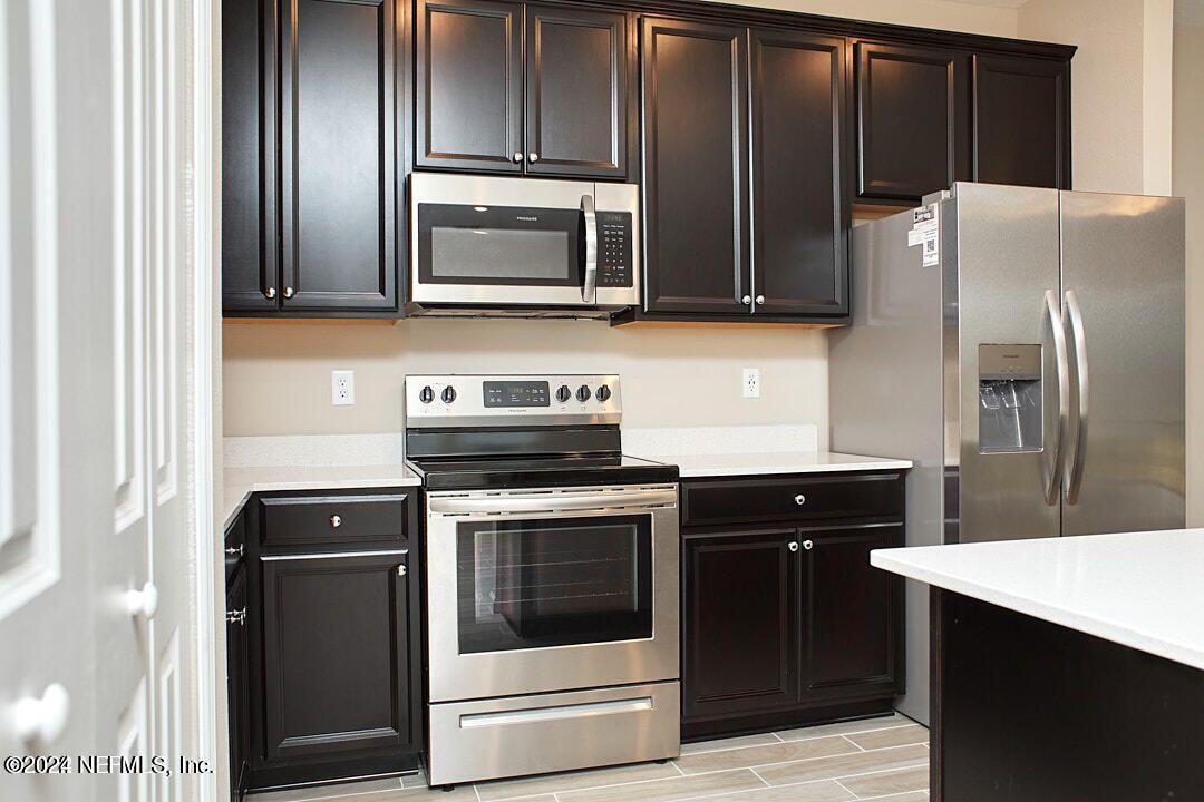 340 Boracay Circle St. Johns, FL 32259 - Photo 16 of 31 a kitchen with granite countertop stainless steel appliances and wooden cabinets