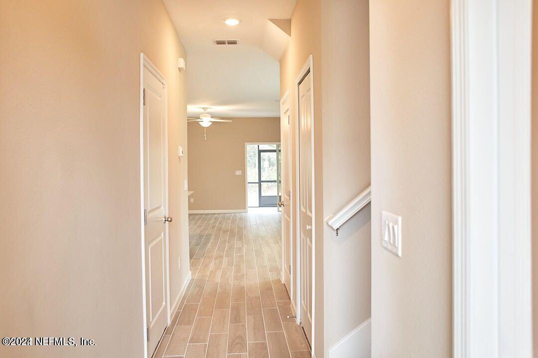 340 Boracay Circle St. Johns, FL 32259 - Photo 6 of 31 a view of a hallway with wooden floor and staircase
