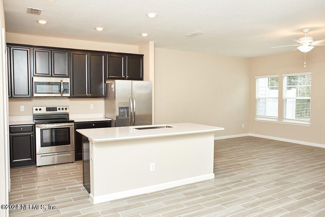 340 Boracay Circle St. Johns, FL 32259 - Photo 9 of 31 a kitchen with kitchen island a stove a refrigerator and a sink