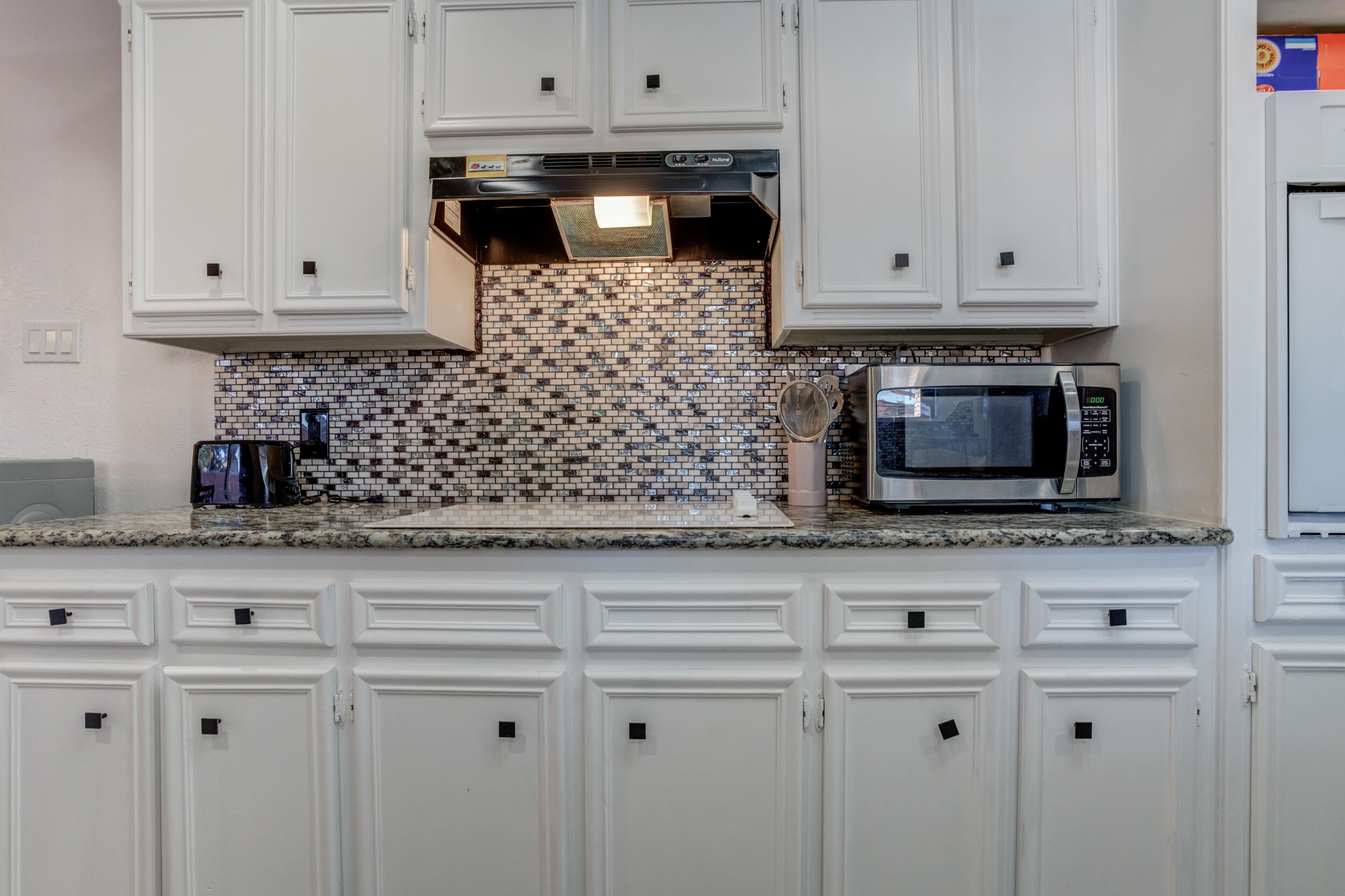4524 79th Street Lubbock, TX 79424 - Photo 18 of 45 a kitchen with white cabinets and appliances