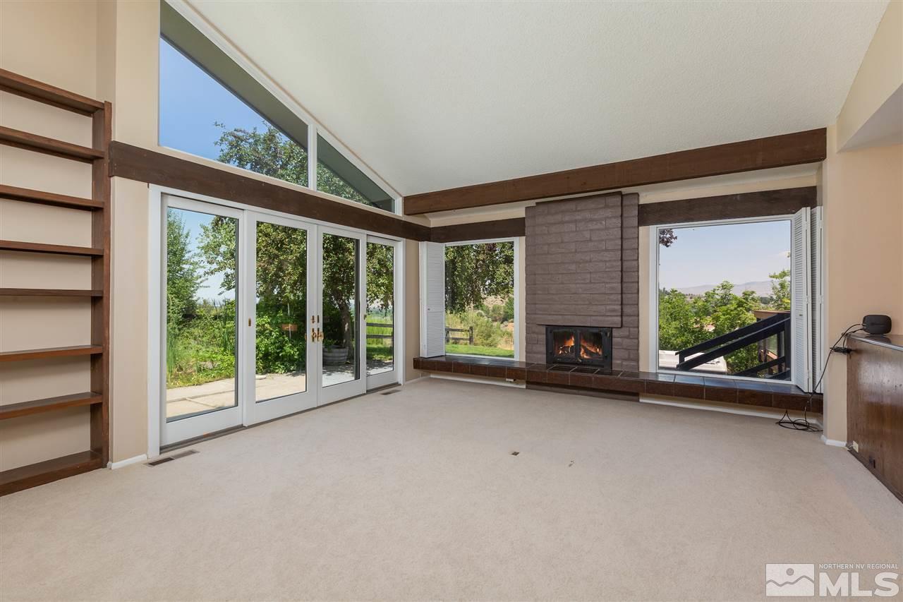3455 Quilici Road Reno, NV 89511 - Photo 3 of 12 a view of an empty room with a fireplace and a window