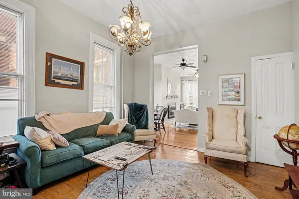 a living room with furniture a chandelier and a rug