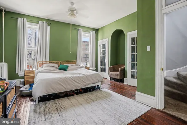 a bedroom with a bed mirror and a large window