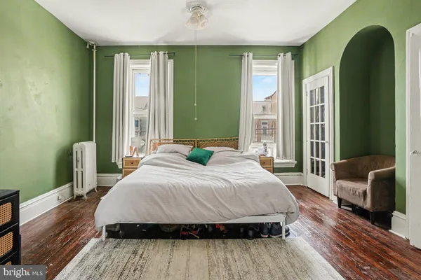 a bedroom with a bed wooden floor and window