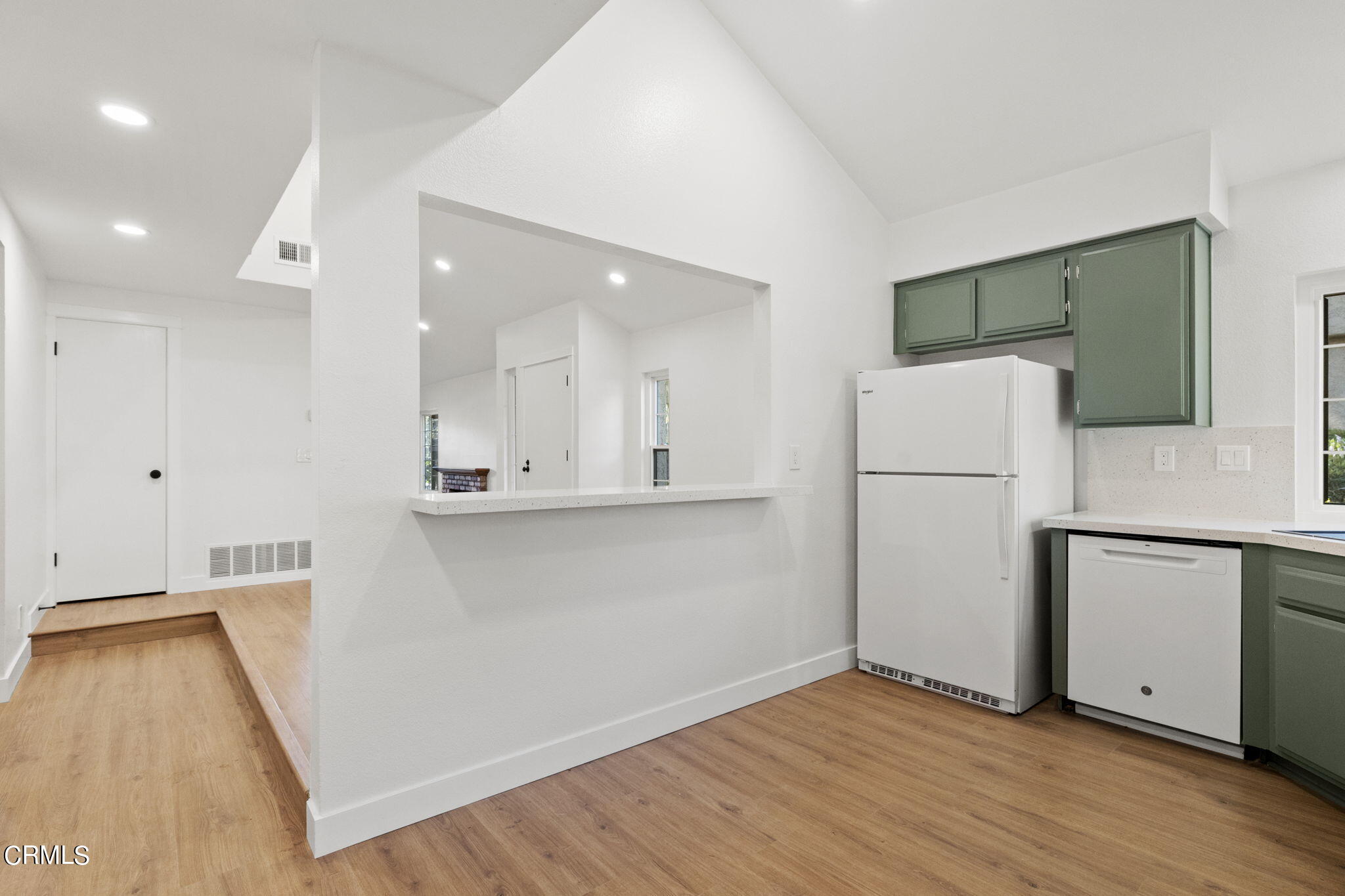 3764 Via Pacifica Walk Oxnard, CA 93035 - Photo 12 of 44 a view of a kitchen with a refrigerator a stove top oven and a wooden floor