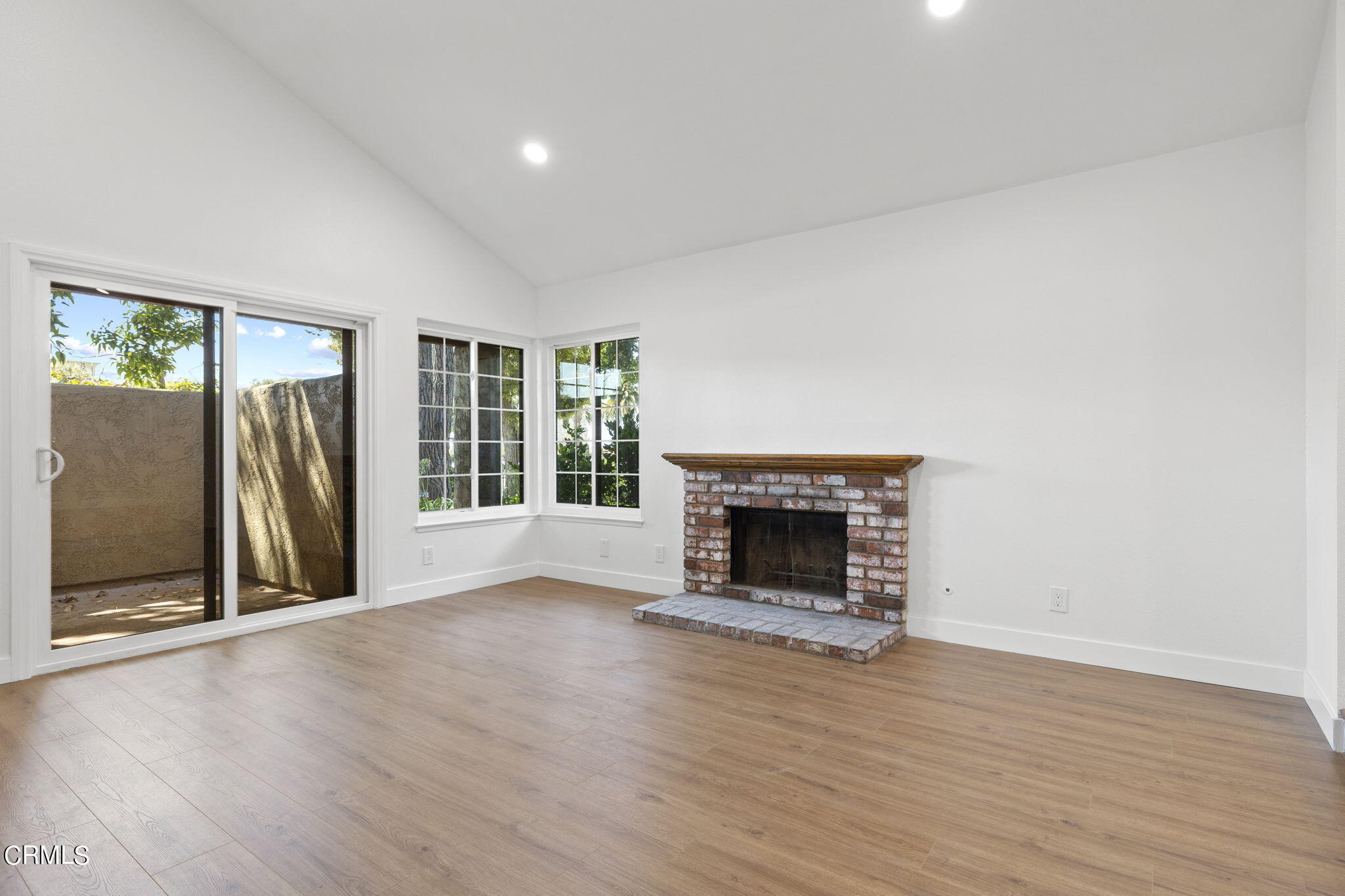 3764 Via Pacifica Walk Oxnard, CA 93035 - Photo 17 of 44 a view of an empty room with wooden floor fireplace and a window