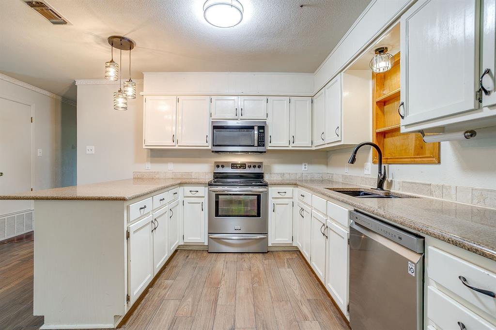 709 North Ave B Springtown, TX 76082 - Photo 12 of 32 a kitchen with granite countertop a sink stainless steel appliances and cabinets